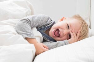 Toddler lying on side laughing